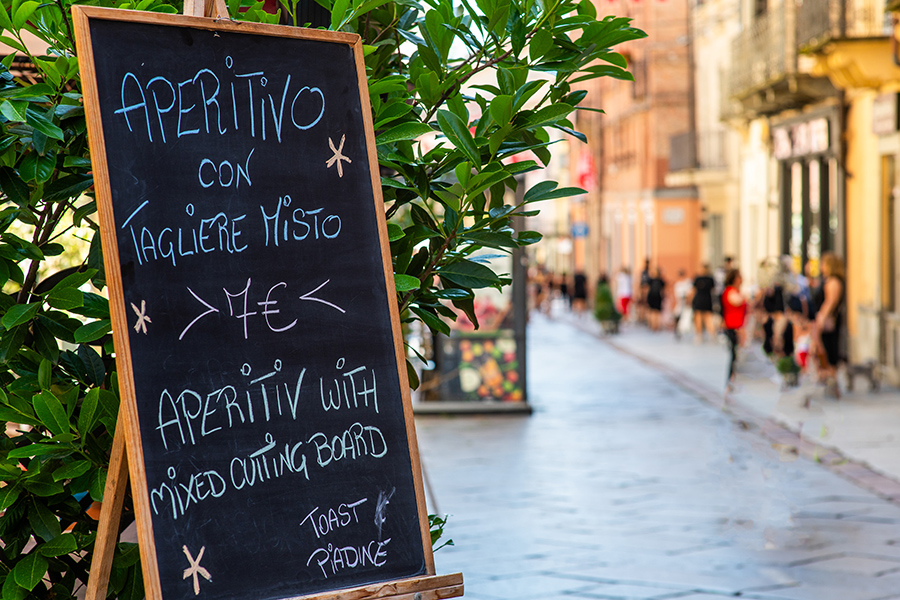 Aperitivo chalkboard on a sunny street in Piedmont, Italy