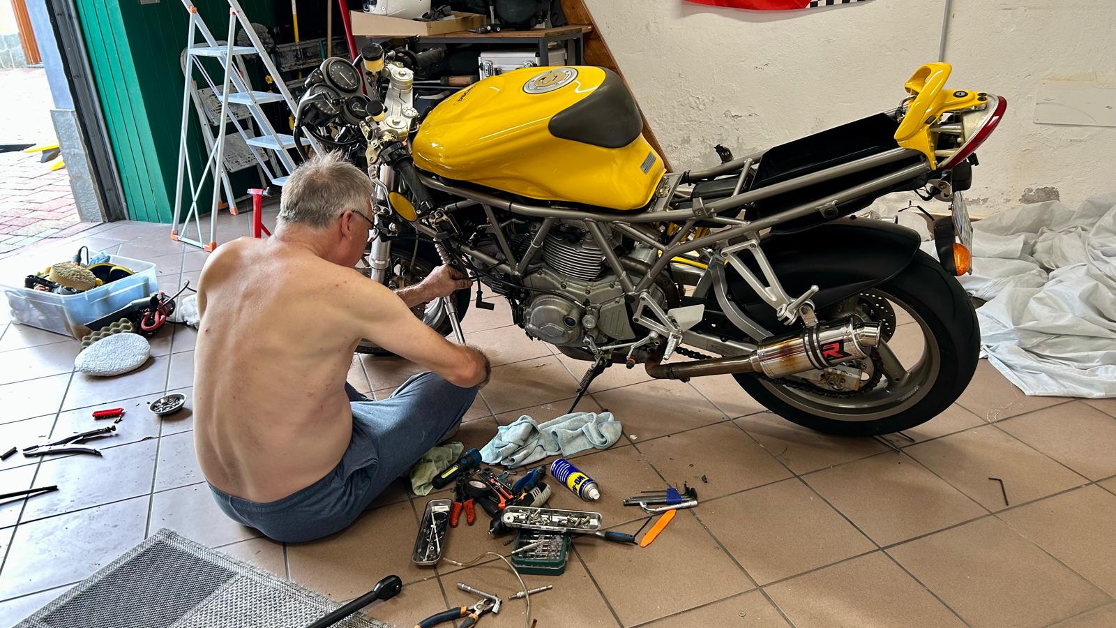 Working on the yellow Ducati 750 SS in the garage