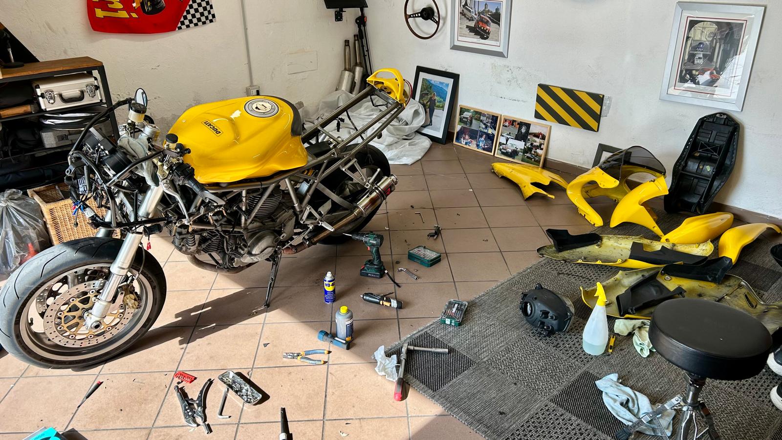 Ducati 750 SS bodywork and tools laid out in the garage